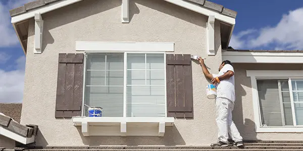 Man painting exterior of a house